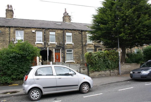 A car parked beside houses on Heaton Road.